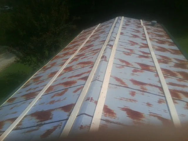 Rusted metal roof panels with new wood purlins before replacement — Storm Damage Roof Repair in Maine by Roofing Brothers