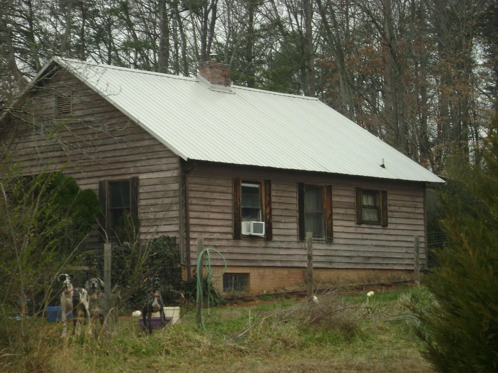 White metal roof on an old wood sided farmhouse, from a Metal Roof Installation job in Maine